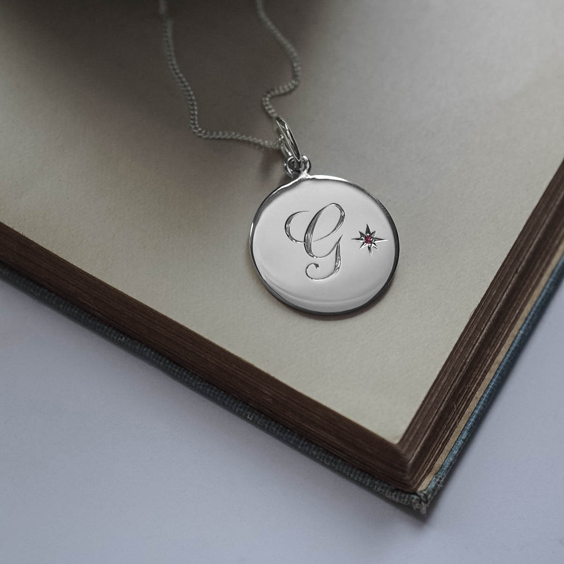 Solid sterling silver Birthstone October Pink Tourmaline Initial Necklace with a hand-engraved scrolled initial and a brilliant-cut Pink Tourmaline set in a Victoriana star-style design, symbolising love, balance, and autumnal elegance.