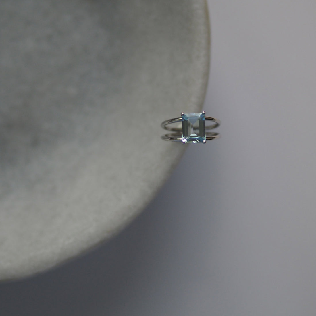 London-crafted Bridal Emerald-Cut Aquamarine Ring by Bianca Jones Jewellery, set on twin platinum bands.