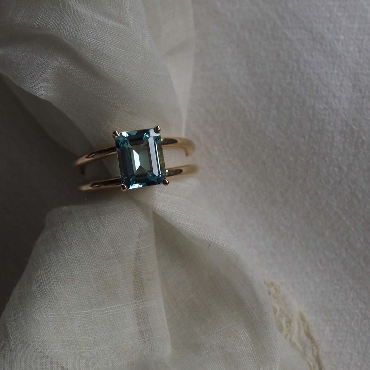 Bridal Emerald-Cut Aquamarine Ring by Bianca Jones Jewellery, London: Joyful aquamarine set on two handcrafted yellow gold bands.