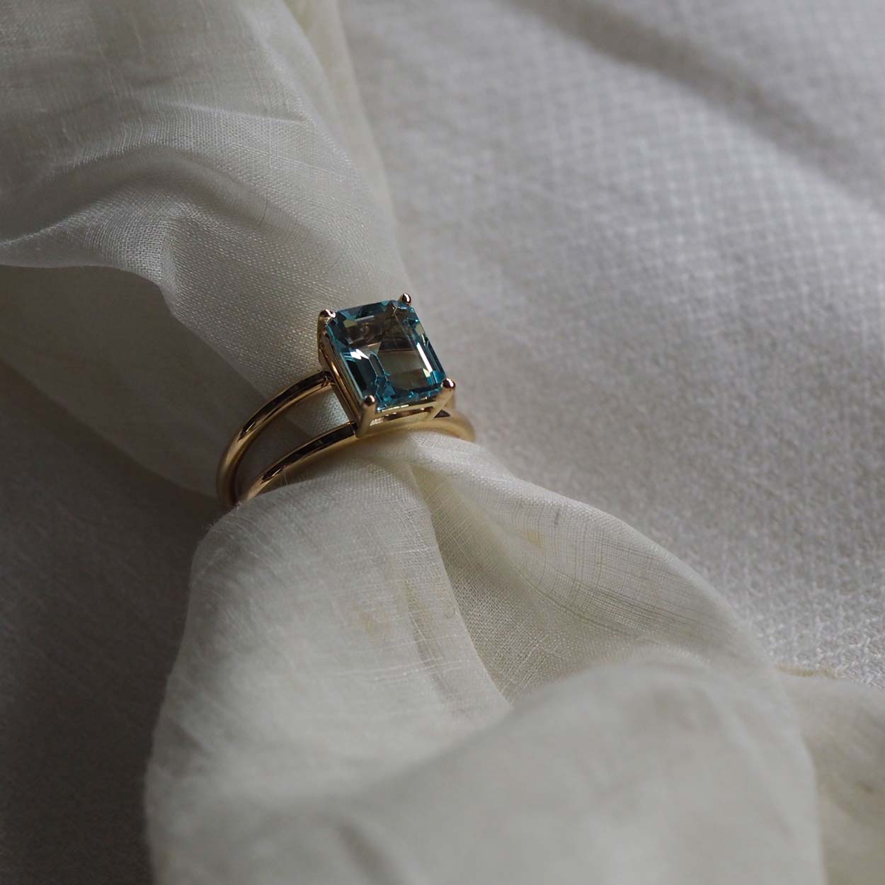 Bridal Emerald-Cut Aquamarine Ring by Bianca Jones Jewellery, London: Joyful aquamarine set on two handcrafted yellow gold bands.