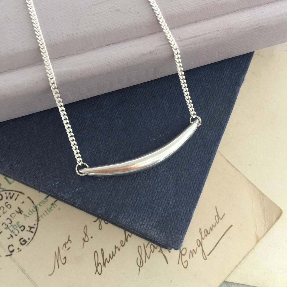 Curved sterling silver bar necklace with Forever Strong engraving, handmade jewellery inspired by strength.