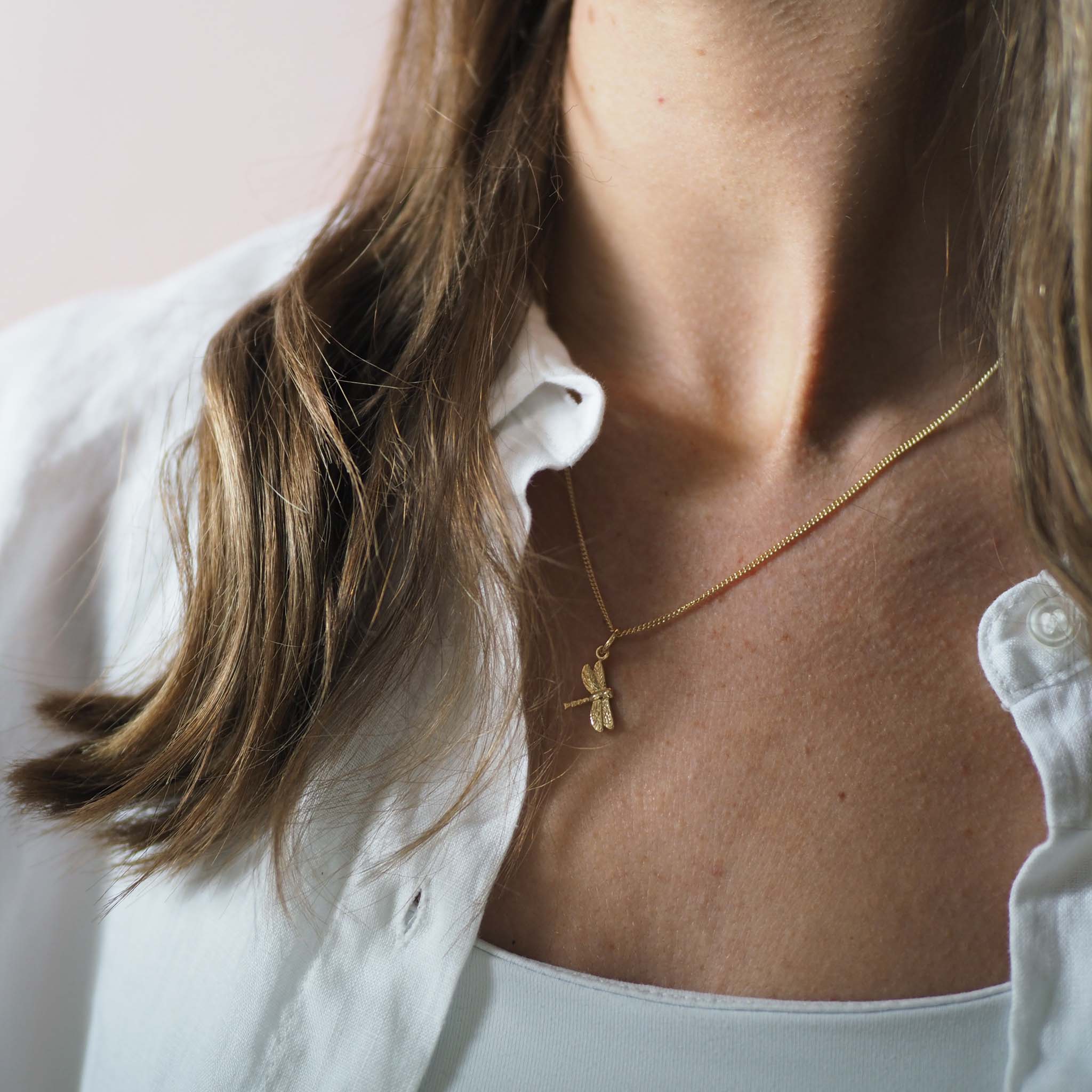 Solid gold dragonfly necklace handcrafted in London, a meaningful talisman of transformation and joy.