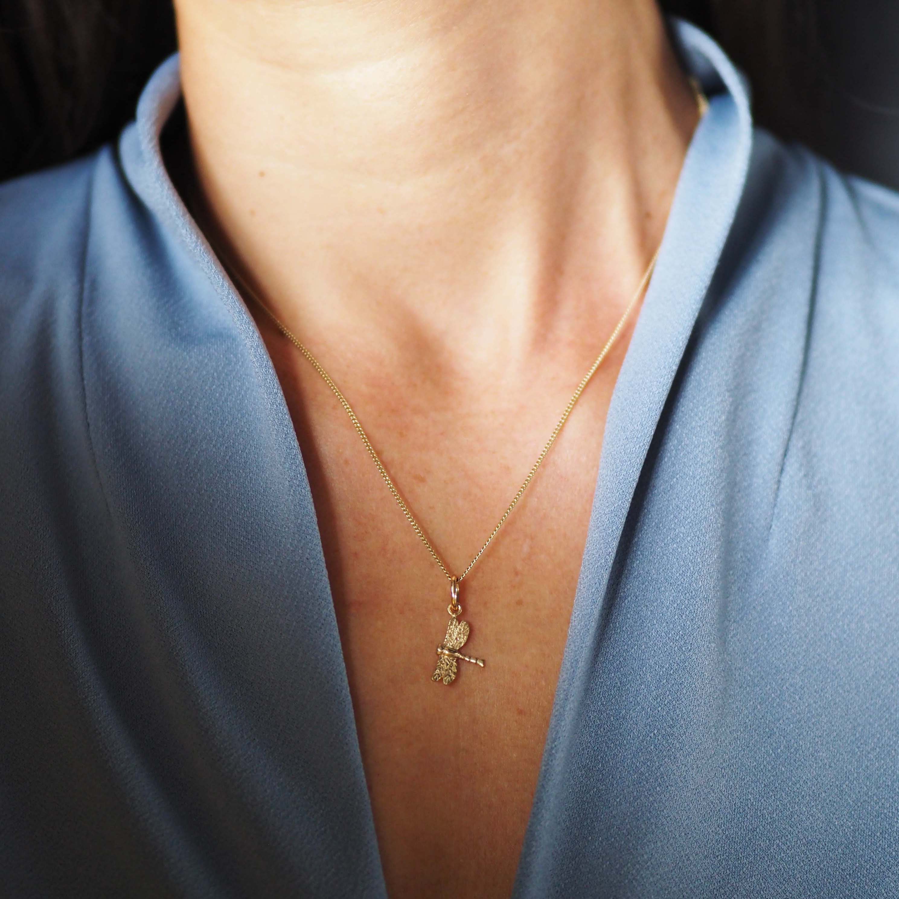 Solid gold dragonfly necklace handcrafted in London, a meaningful talisman of transformation and joy.