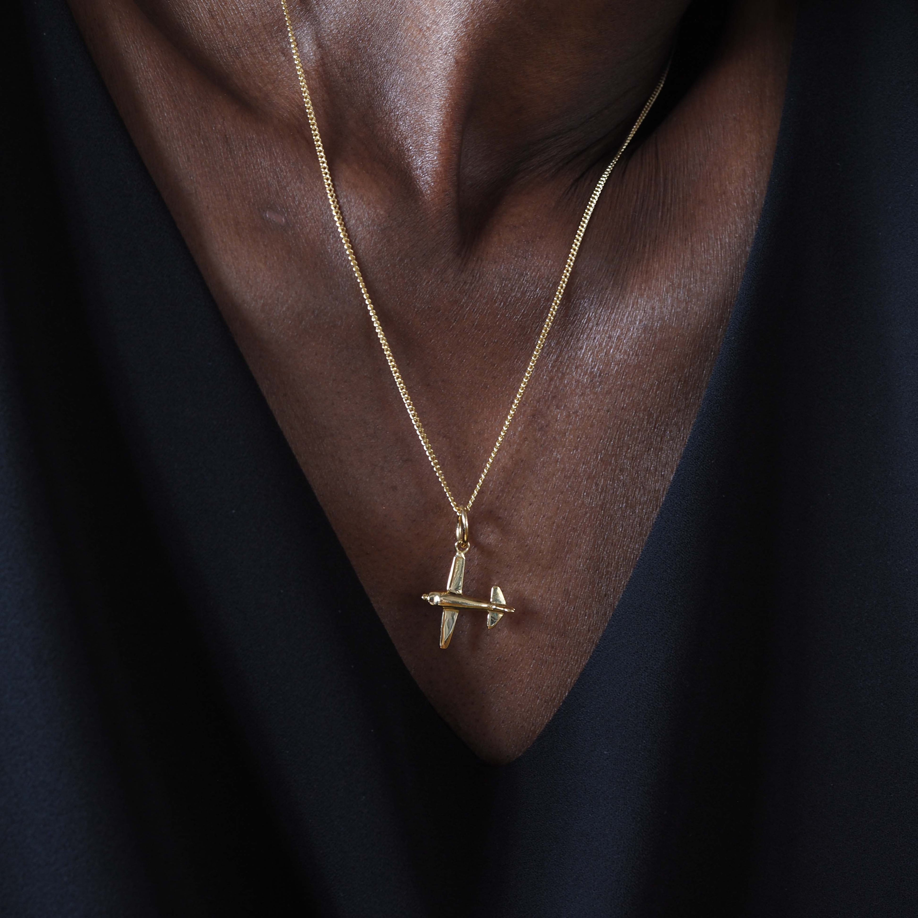 18ct gold airplane charm necklace. A polished solid gold pendant symbolising travel and freedom. Available in yellow, rose, or white gold.