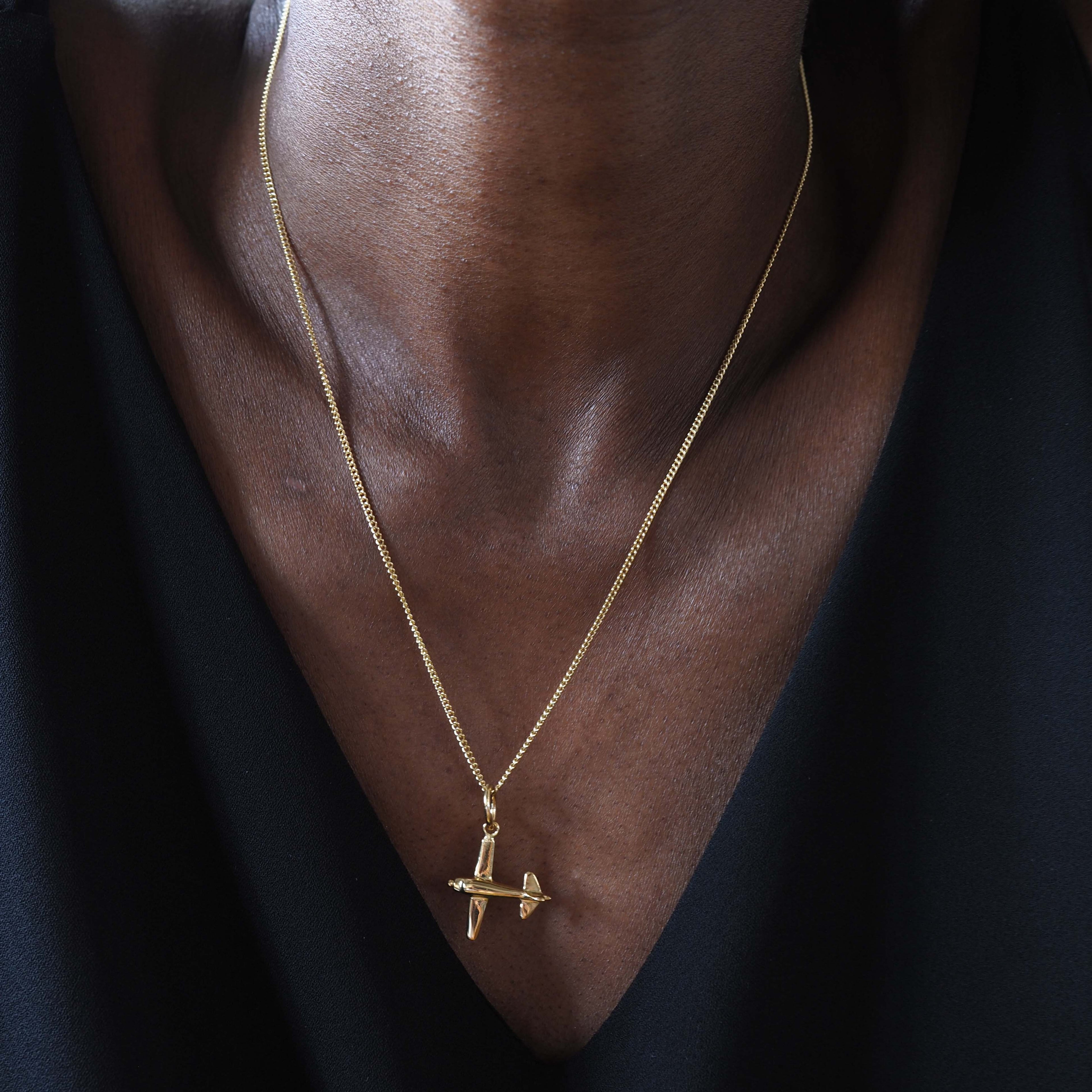 18ct gold airplane charm necklace. A polished solid gold pendant symbolising travel and freedom. Available in yellow, rose, or white gold.