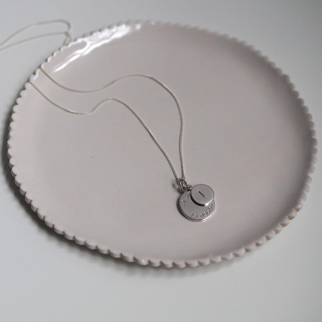 Personalised Latitude & Longitude Mini Initial Necklace in Solid Silver with hand-engraved coordinates and initial. A meaningful keepsake of cherished memories.