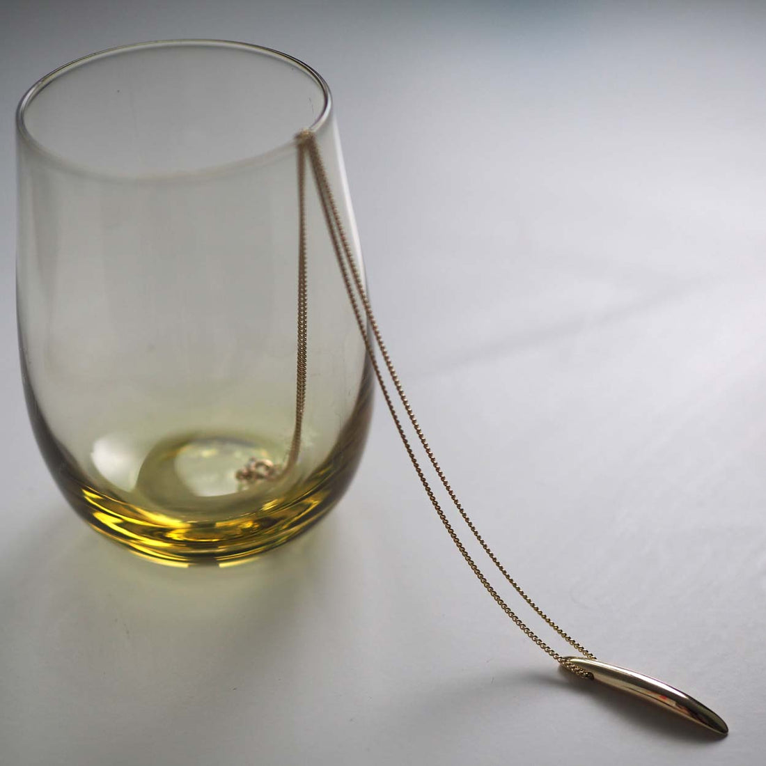 Sculptural solid gold bar necklace with a curved Brancusi-inspired form – Forever Strong Necklace, handmade in London.