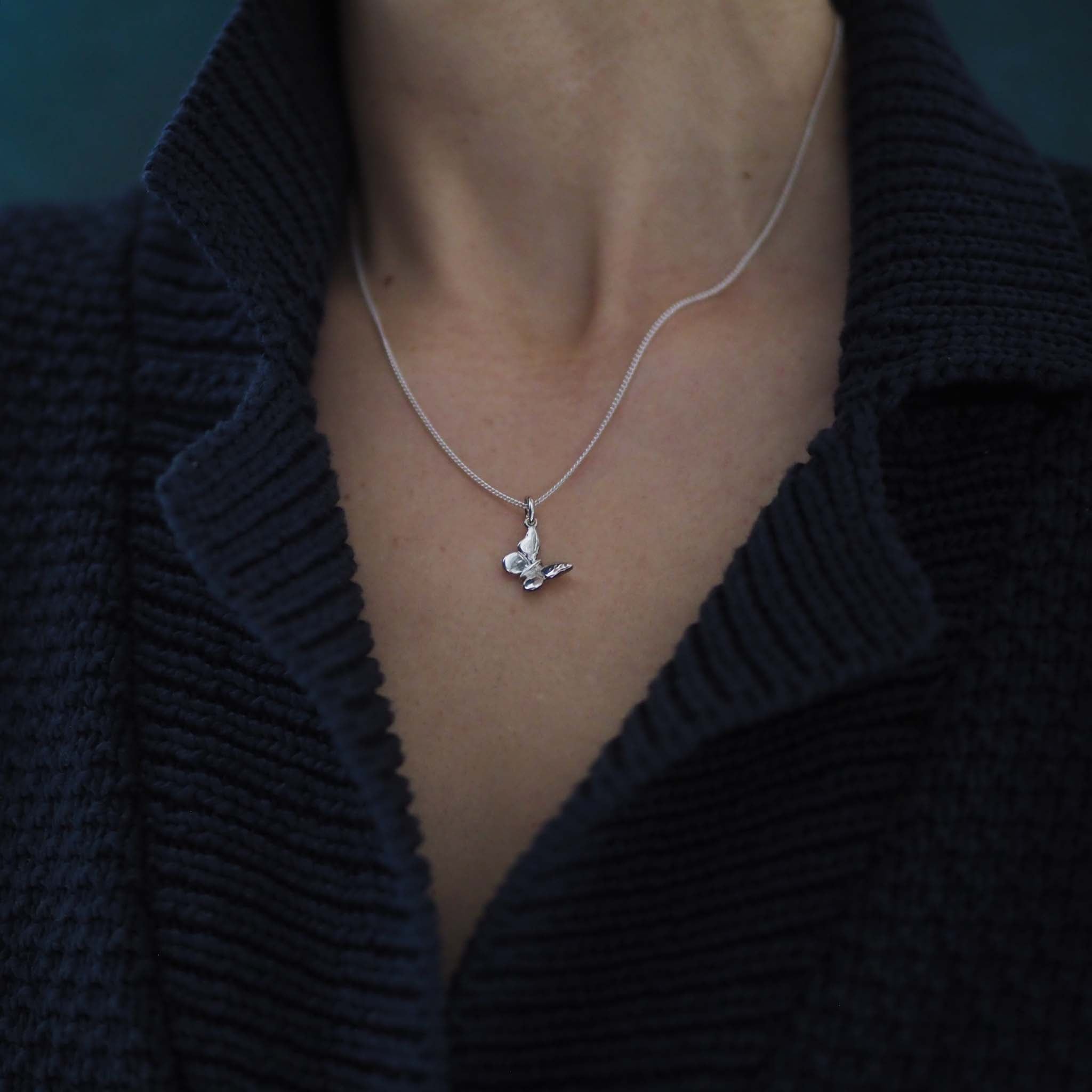 Woman wearing the Butterfly Necklace in solid gold, a modern talisman of change and new beginnings.