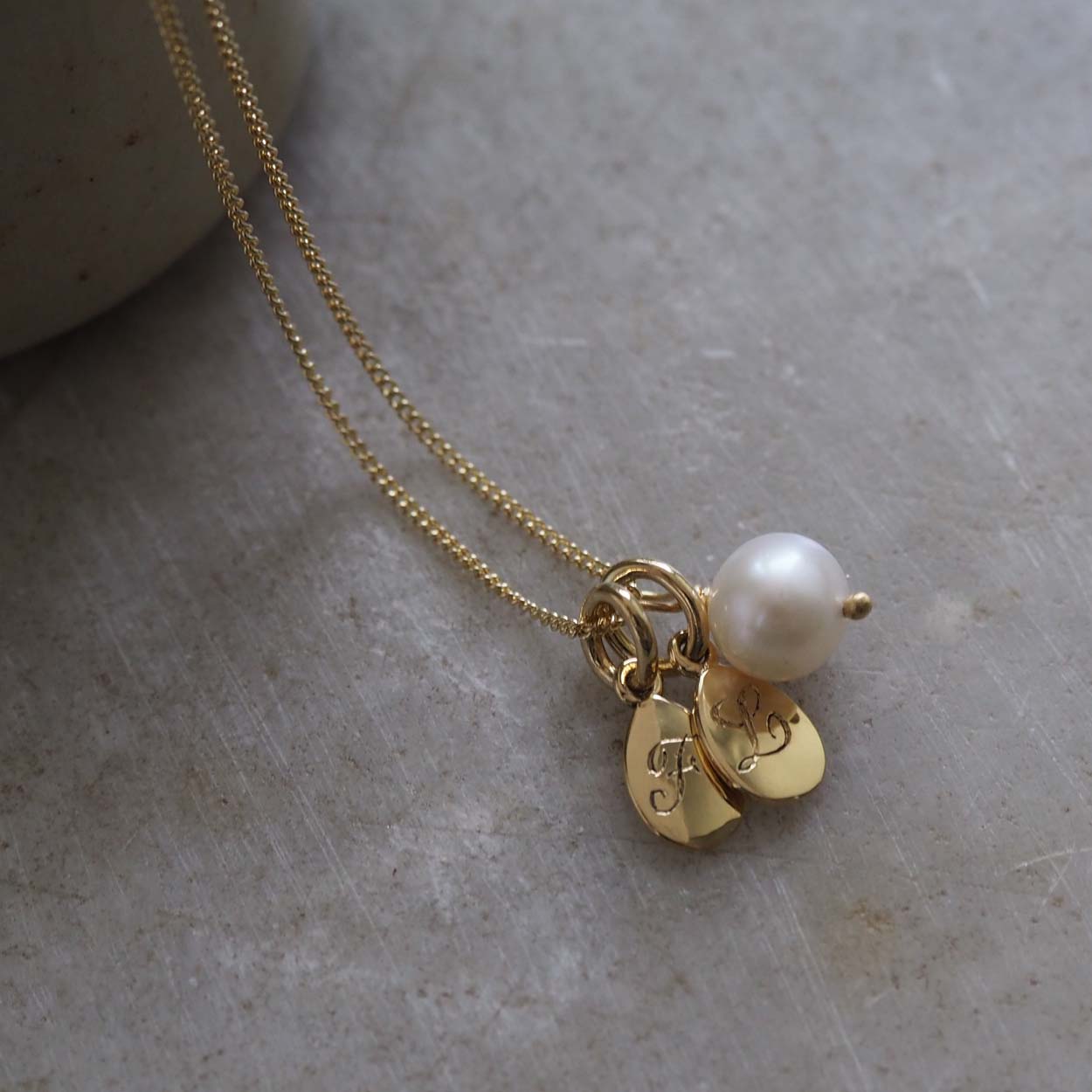 Initial Double Teardrop and Pearl Necklace in solid gold with engraved charms and freshwater pearl on side angle