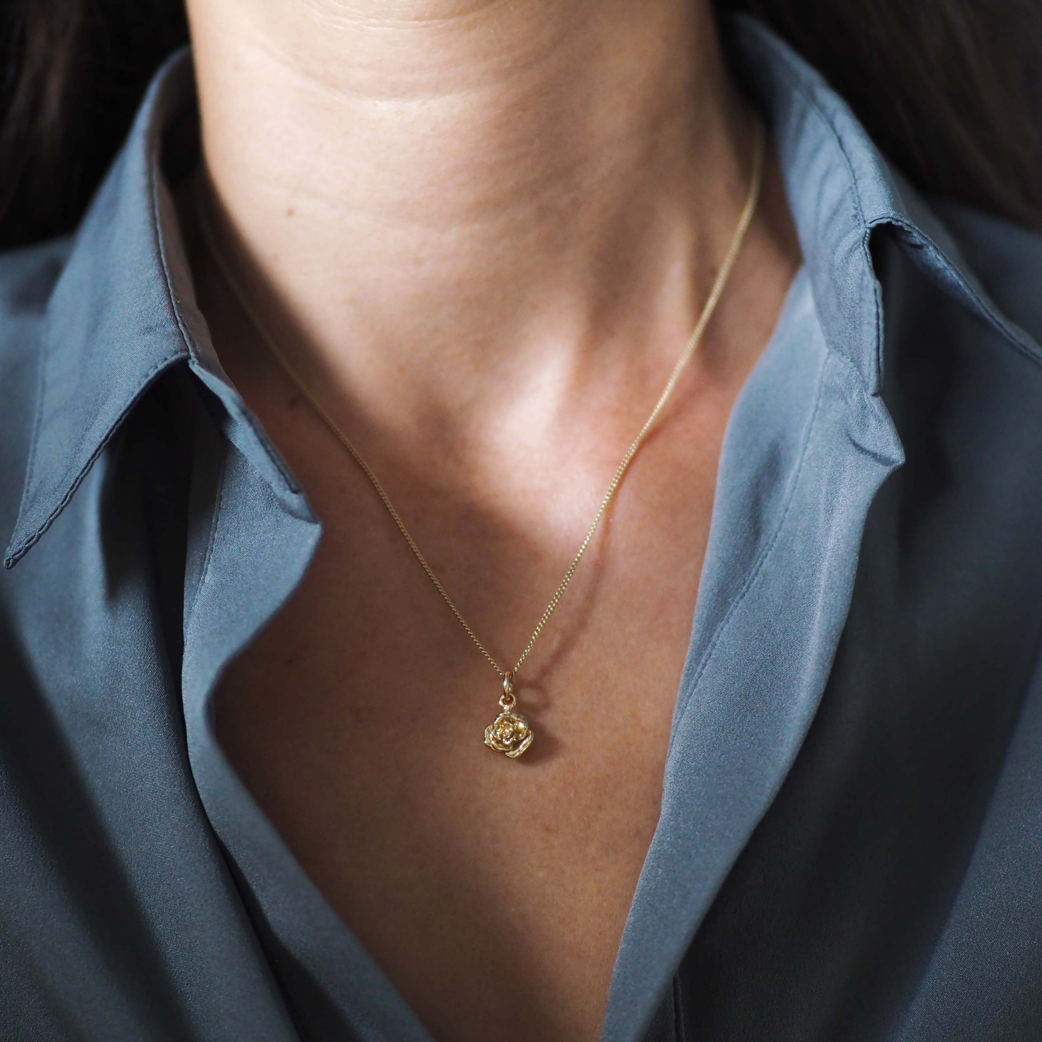 Woman wearing the Rose Necklace in 9ct solid gold, a talisman of love, resilience, and quiet strength