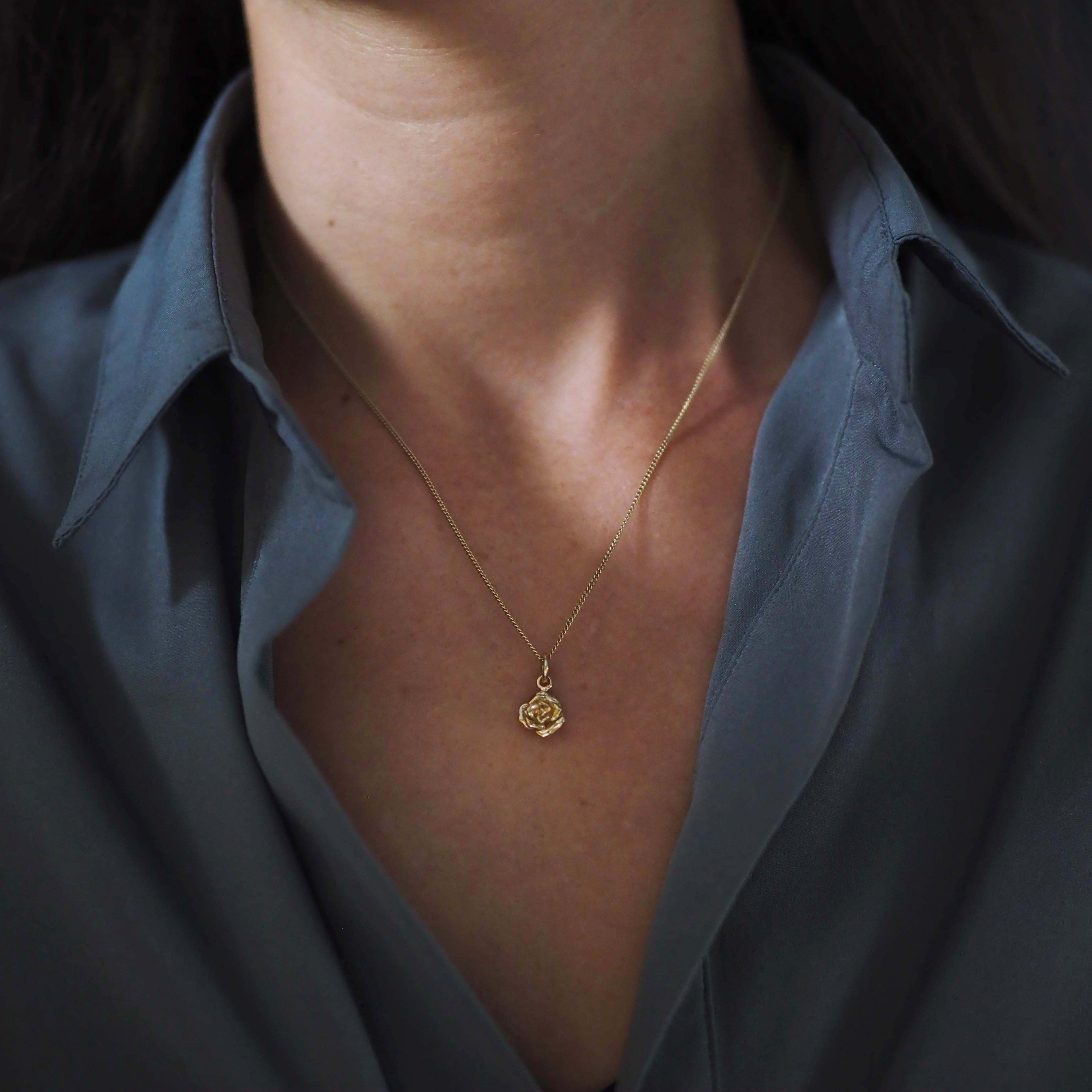 Woman wearing the Rose Necklace in 9ct solid gold, a talisman of love, remembrance, and quiet strength.