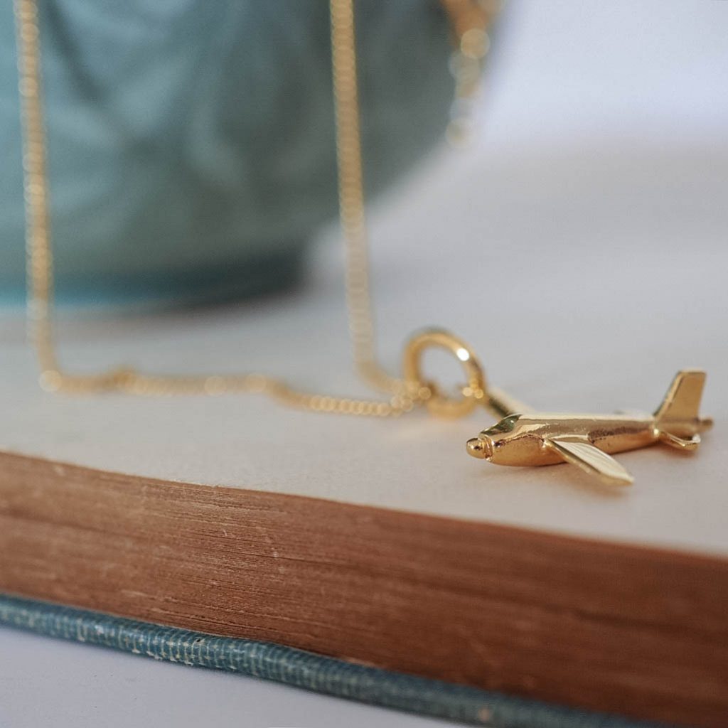 9ct gold airplane charm necklace. A polished solid gold pendant symbolising travel and freedom. Available in yellow, rose, or white gold.