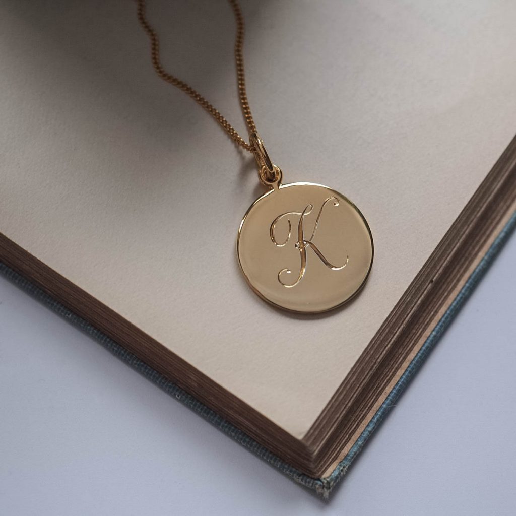 Bianca Jones hand-engraved script initial charm, available in silver or gold vermeil, featuring elegant detailing and personalised craftsmanship