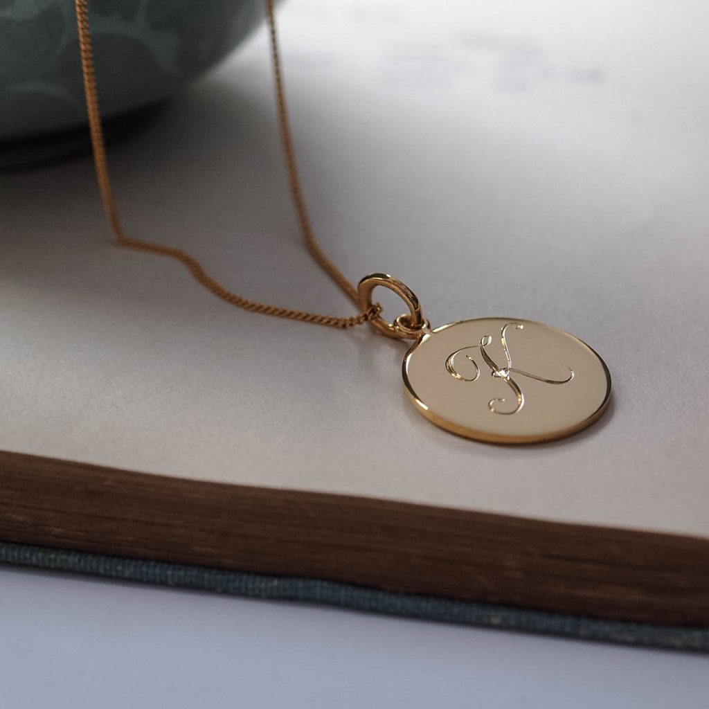 Bianca Jones hand-engraved script initial charm, available in silver or gold vermeil, featuring elegant detailing and personalised craftsmanship