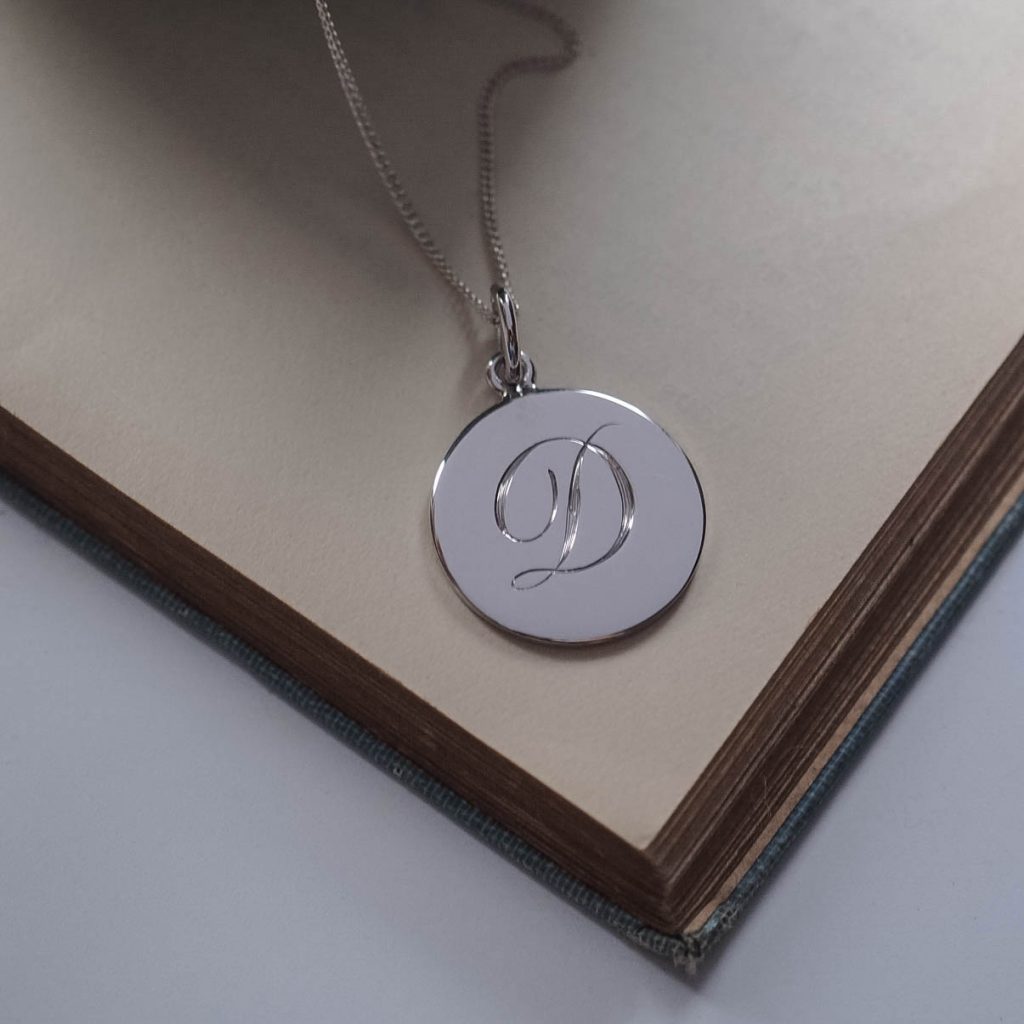 Bianca Jones hand-engraved script initial charm available in silver or gold vermeil, offering a personalised touch of elegance