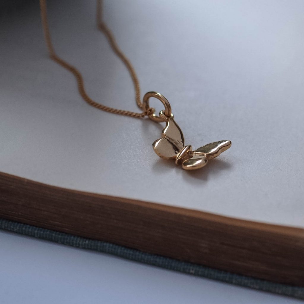 Close-up of the Butterfly Necklace in solid gold, showing the intricate hand-textured design