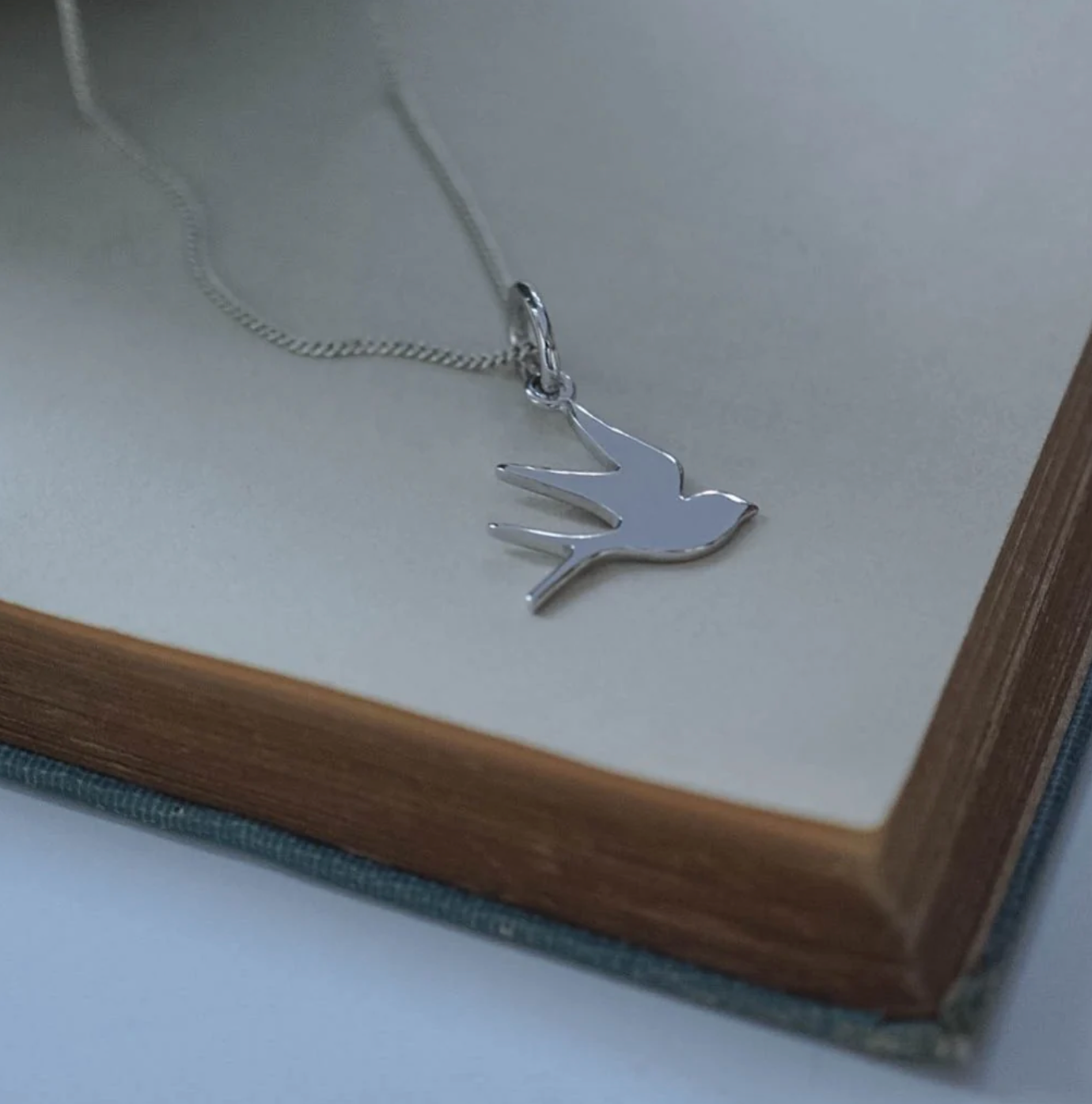 Close-up of the Swallow Necklace by Bianca Jones, symbolising loyalty, freedom, and hope.