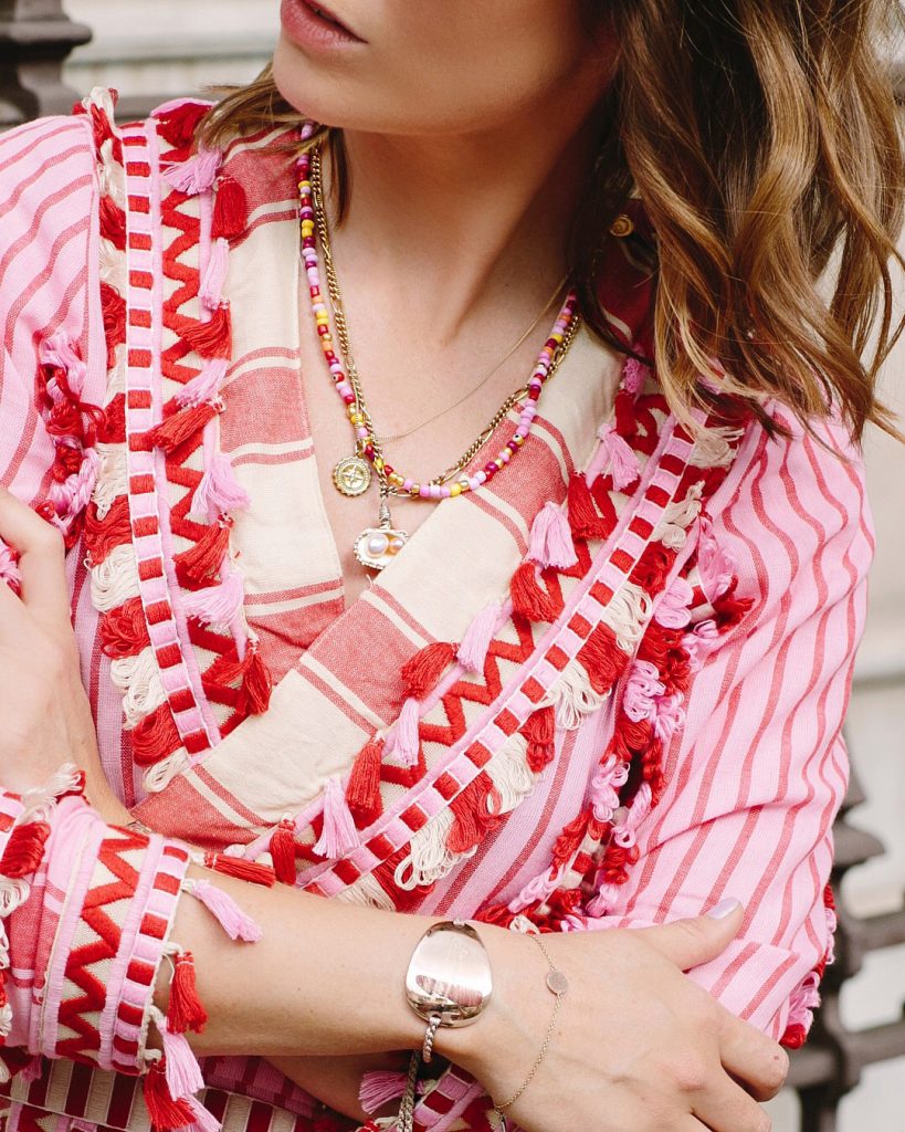 Kelly Eastwood, The London Chatter, wearing the golden Compass Necklace by Bianca Jones Jewellery, layered with other necklaces, symbolizing guidance and direction in her chic, layered jewelry style.