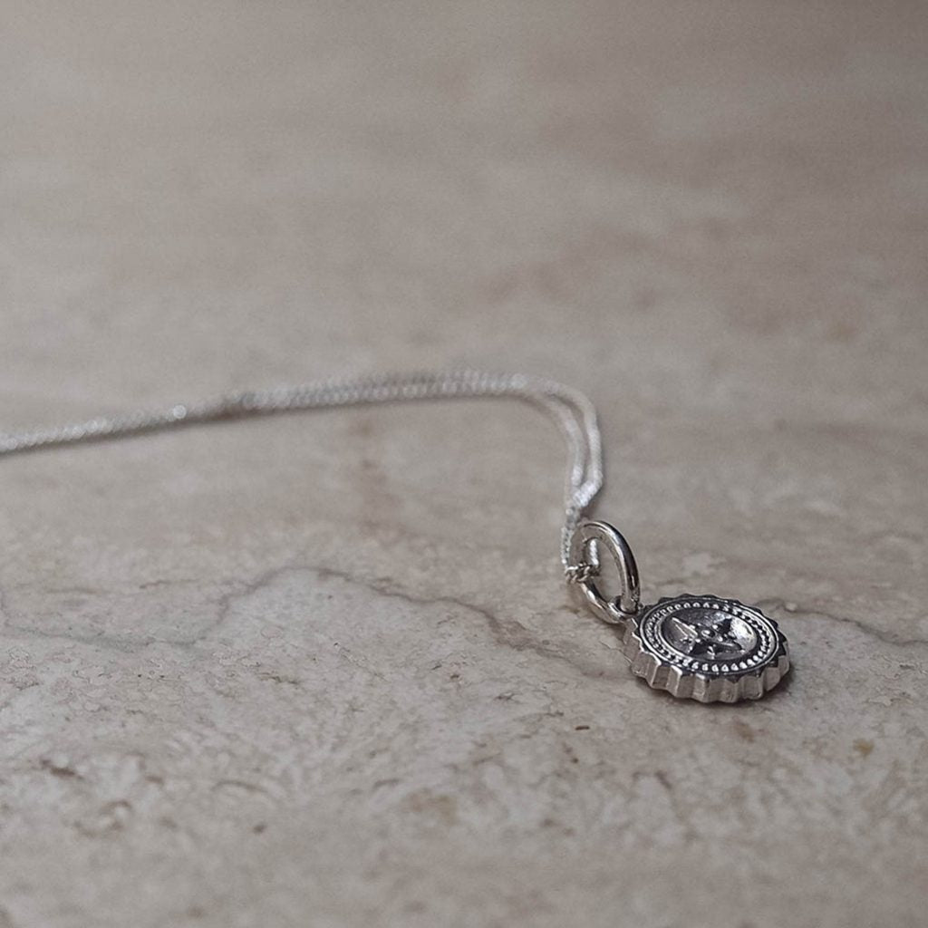 Bianca Jones compass baby necklace available in sterling silver or gold vermeil, symbolising guidance and adventure for explorers.