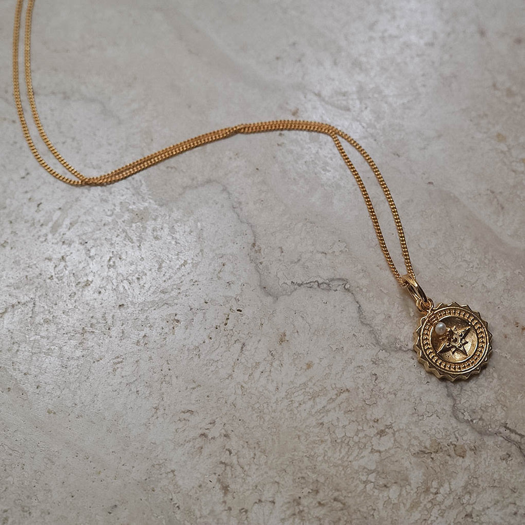 Bianca Jones Compass Midi Necklace with Pearl: Symbolizes guidance, wisdom, and purity, inspiring confidence and adventure in embracing the unknown.