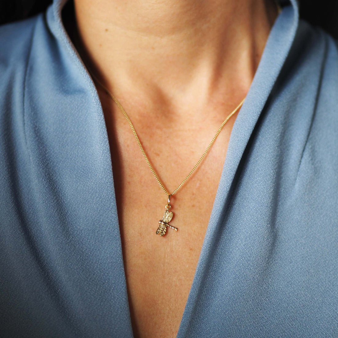 Solid gold dragonfly necklace handcrafted in London, a meaningful talisman of transformation and joy.