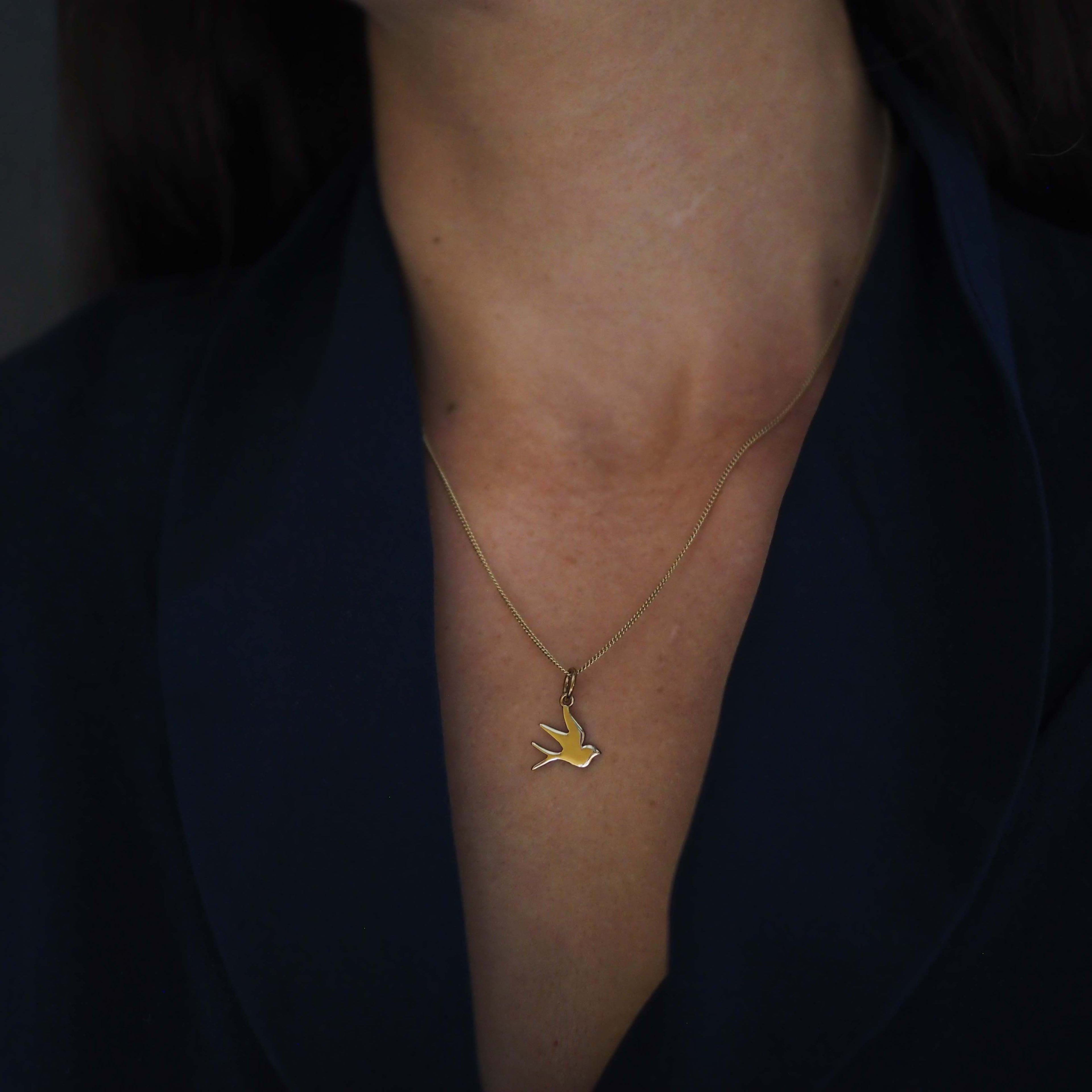 Solid gold swallow necklace symbolising love, loyalty, and freedom, available in yellow, rose, or white gold.