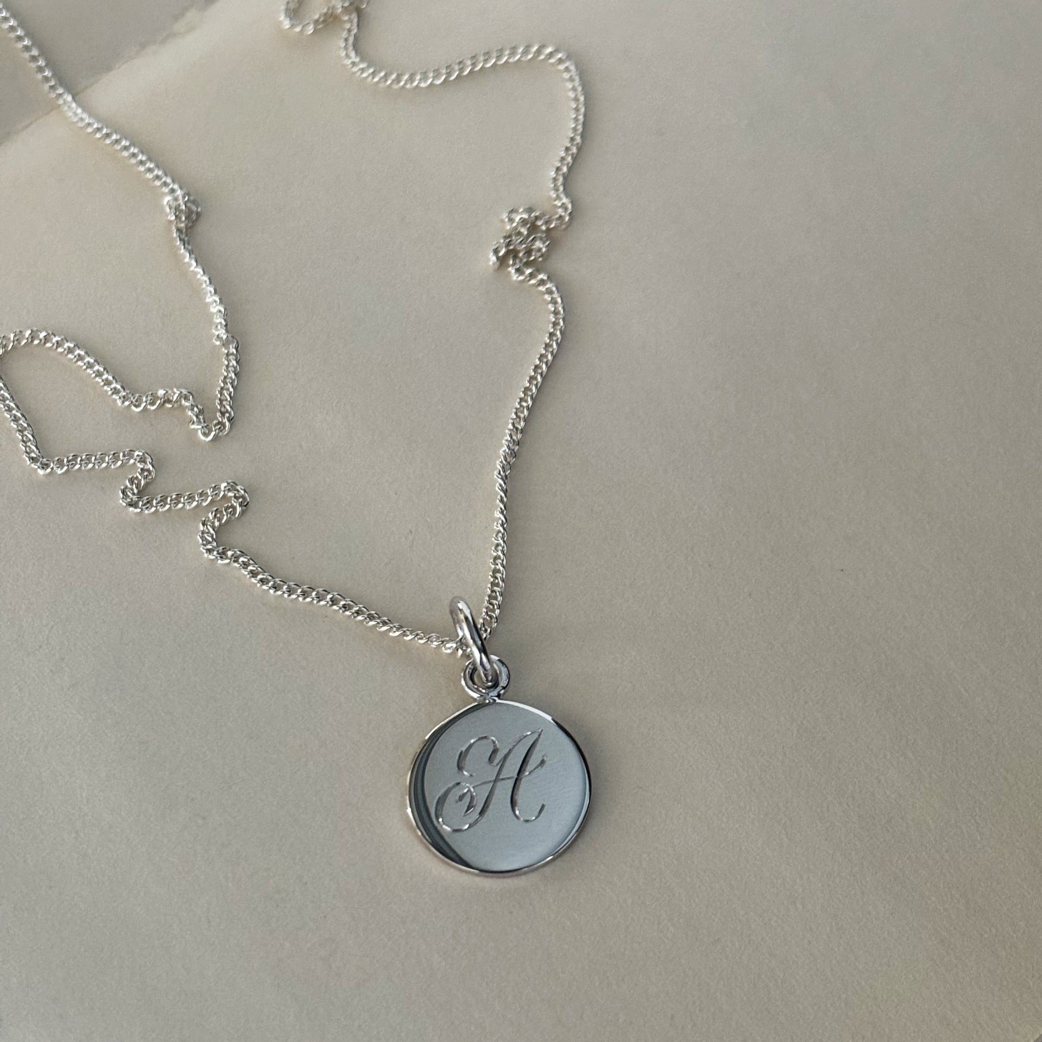 Initial Mini Necklace Bianca Jones Initial Mini Necklace in Solid Gold with a hand-engraved scrolled initial, available in yellow, rose, or white gold. A delicate piece for personal storytelling and meaningful gifting.