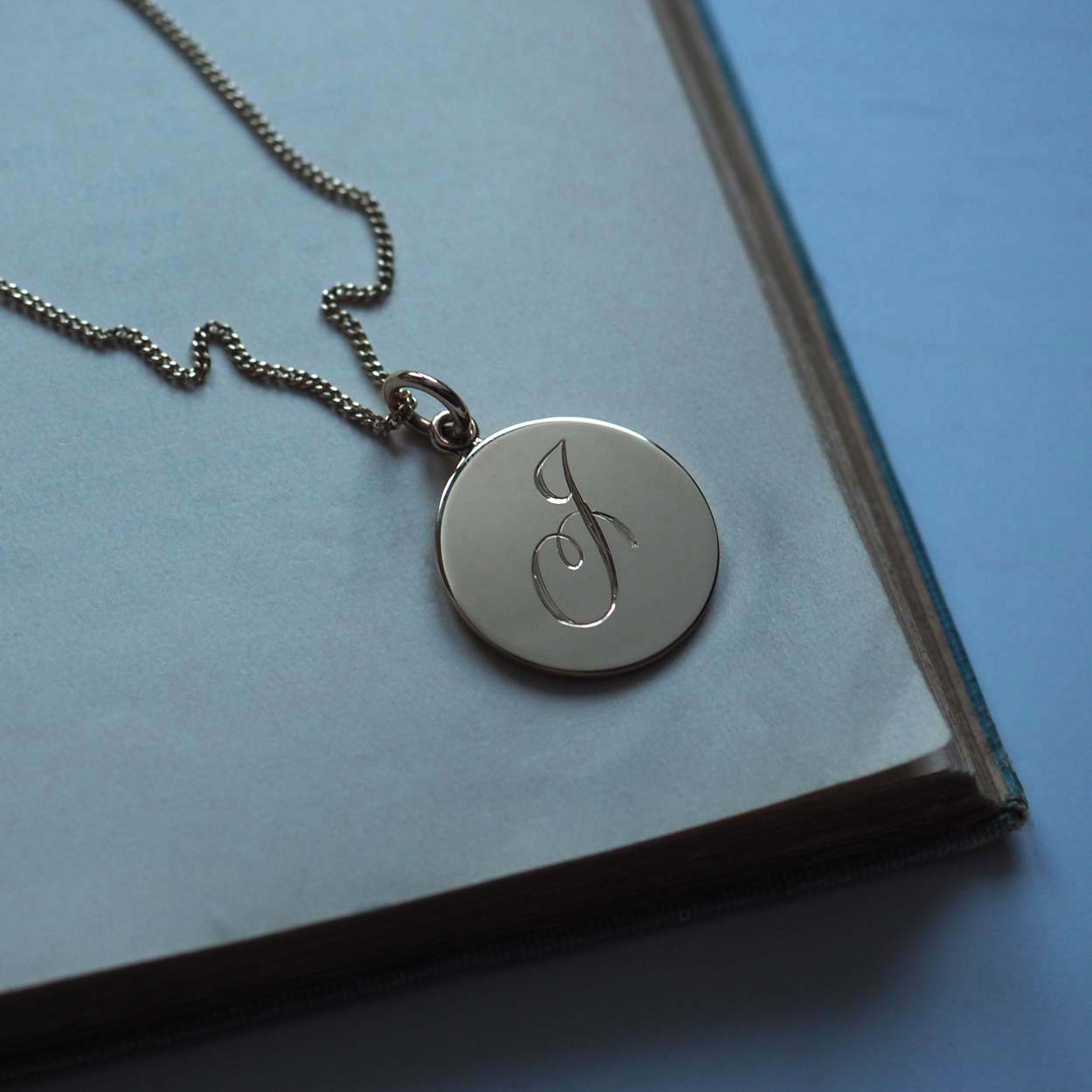 Bianca Jones handcrafted and hand-engraved solid 9ct gold initial charm, available in rose, white, or yellow gold, showcasing bespoke craftsmanship.