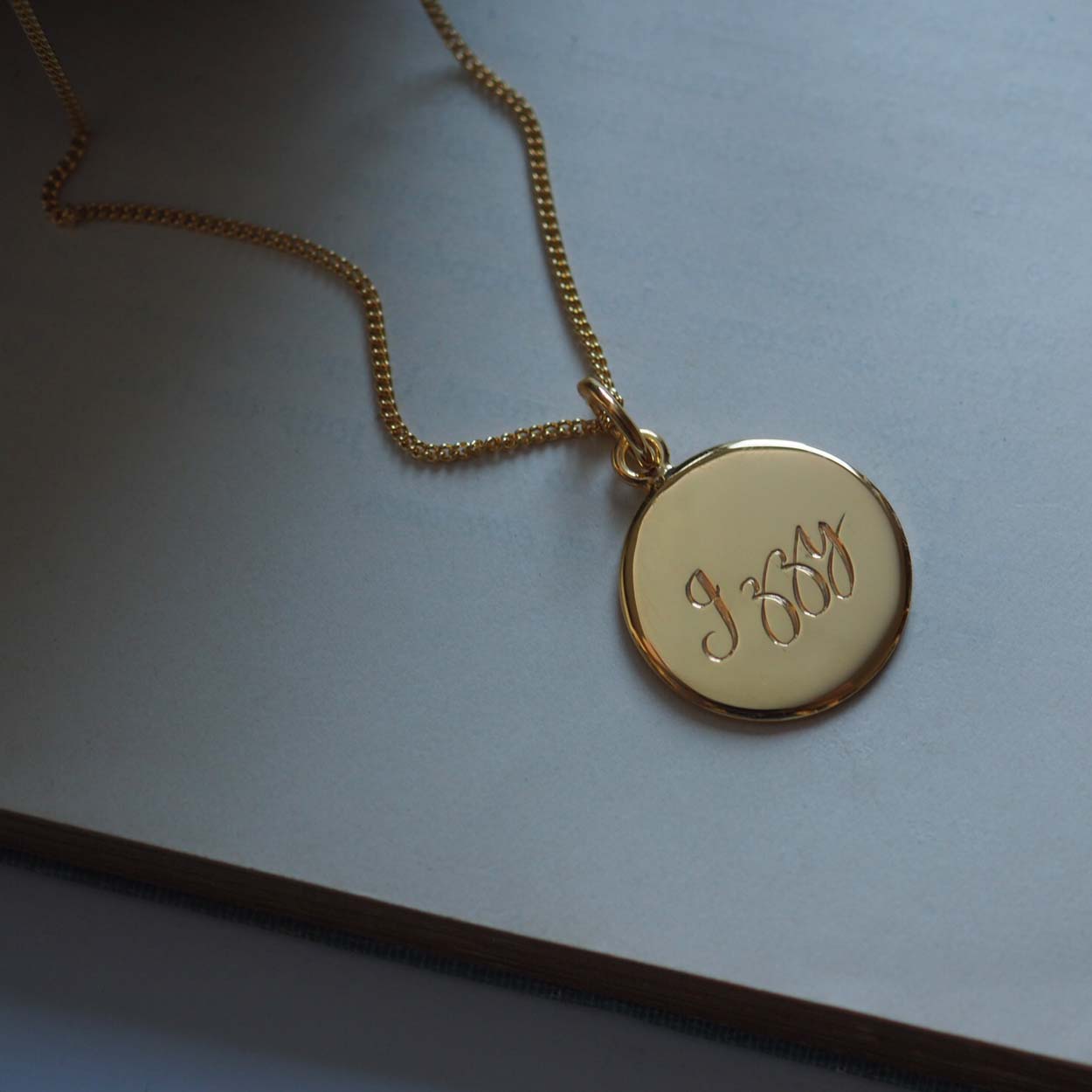 Personalised Name Necklace in Solid Sterling Silver or Gold Vermeil, featuring hand-engraved scrolled text. A timeless symbol of love and connection.