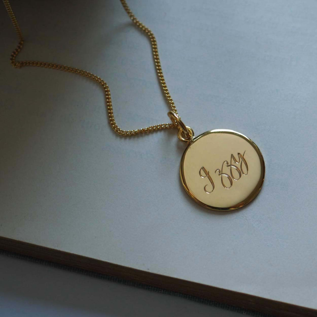 Personalised Name Necklace in Solid Sterling Silver or Gold Vermeil, featuring hand-engraved scrolled text. A timeless symbol of love and connection.