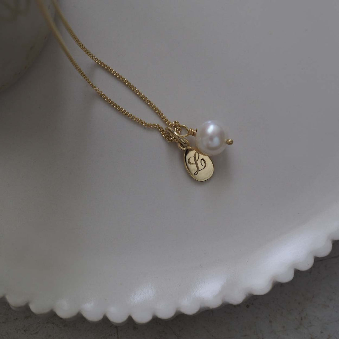 Teardrop Initial and Pearl Necklace in Solid Gold with an engraved teardrop pendant and a pearl charm. A timeless piece symbolising love and cherished connections.