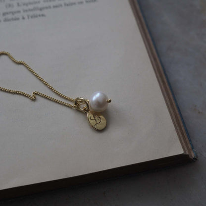 Teardrop Initial and Pearl Necklace in Solid Gold with an engraved teardrop pendant and a pearl charm. A timeless piece symbolising love and cherished connections.