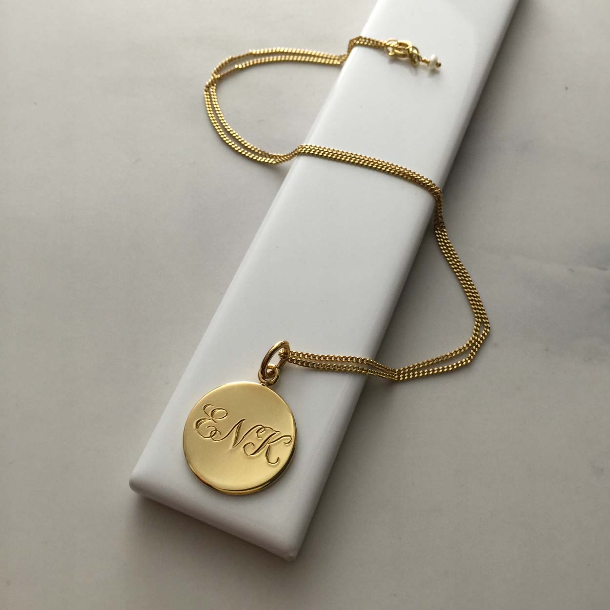 Triple Initial Necklace in Yellow Gold Vermeil, hand-engraved with three intertwined initials. A timeless keepsake representing cherished connections and love.