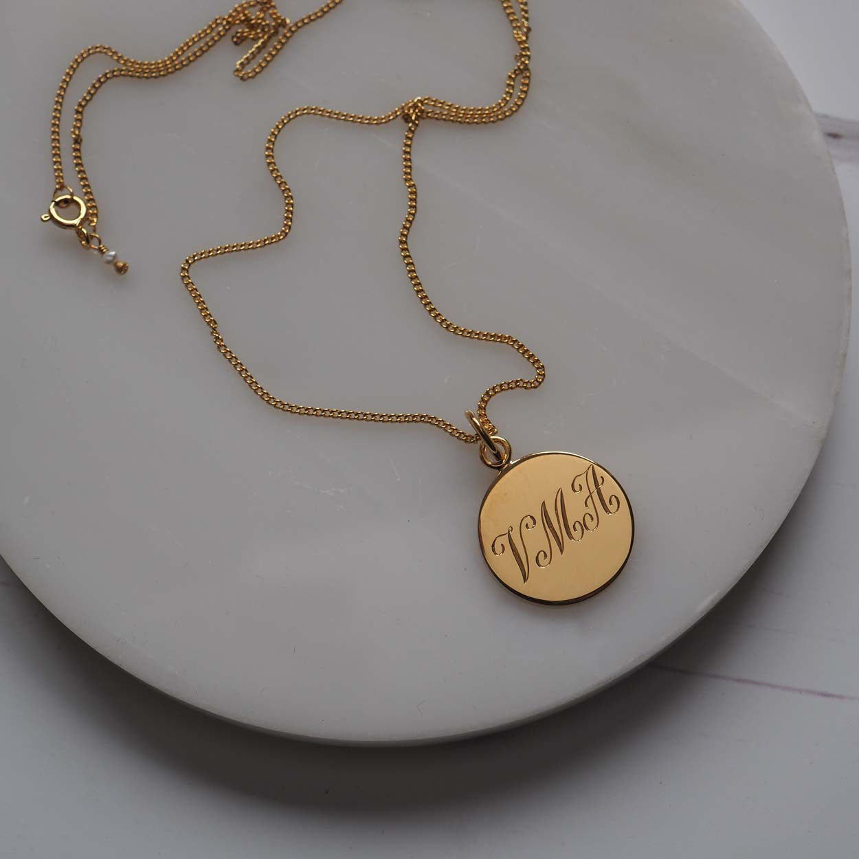 Triple Initial Necklace in Yellow Gold Vermeil, hand-engraved with three intertwined initials. A timeless keepsake representing cherished connections and love.