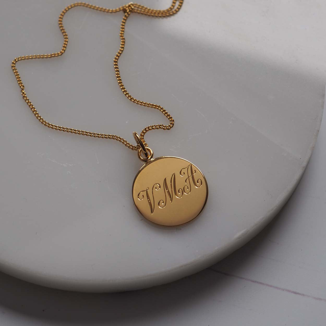 Triple Initial Necklace in Yellow Gold Vermeil, hand-engraved with three intertwined initials. A timeless keepsake representing cherished connections and love.