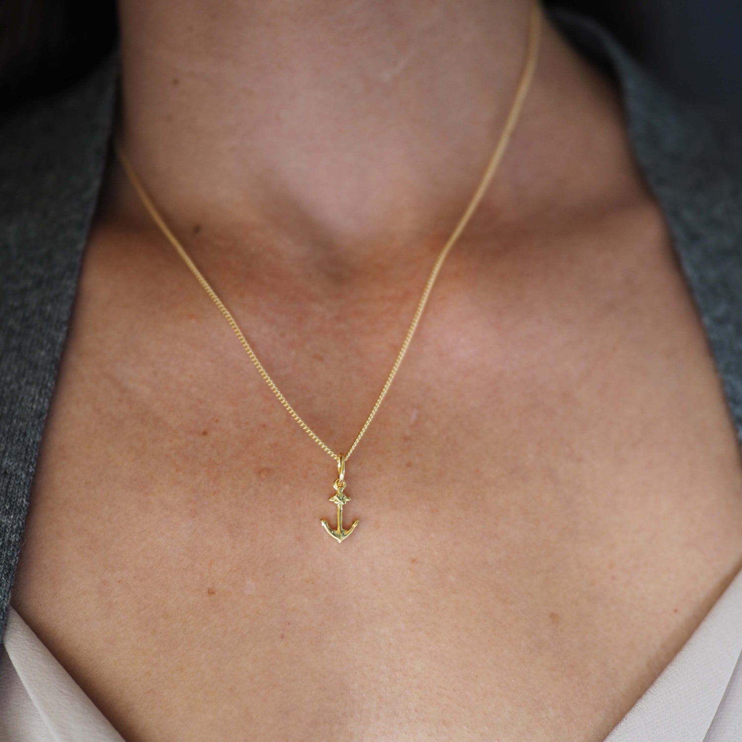 18ct gold anchor pendant necklace styled with a pink blouse 