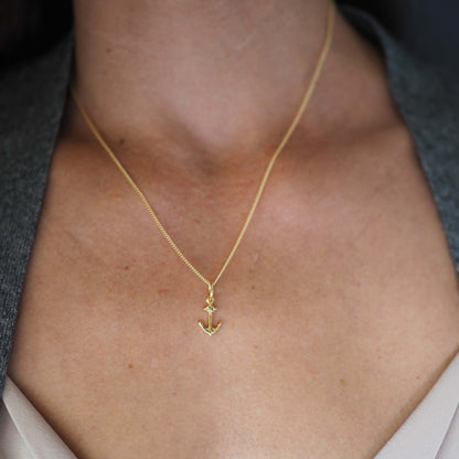18ct gold anchor pendant necklace styled with a pink blouse 