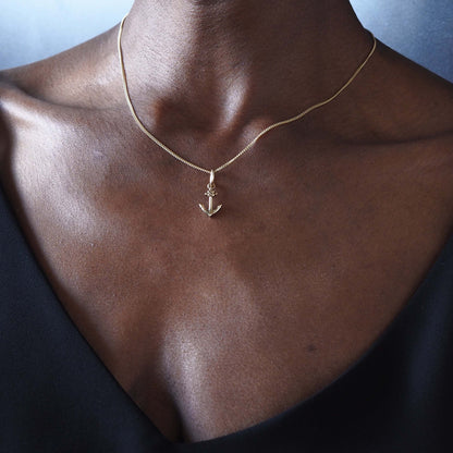 Gold anchor necklace made by Bianca Jones close-up on model’s neck and collarbone