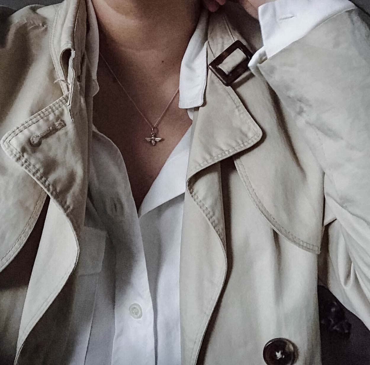 Close up of sterling silver bee necklace pendant on model, recycled silver