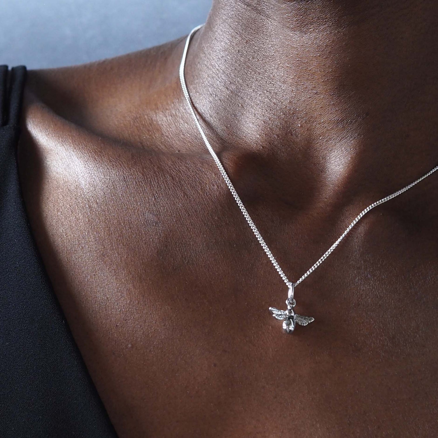 Model wearing sterling silver bee necklace, 18-inch chain