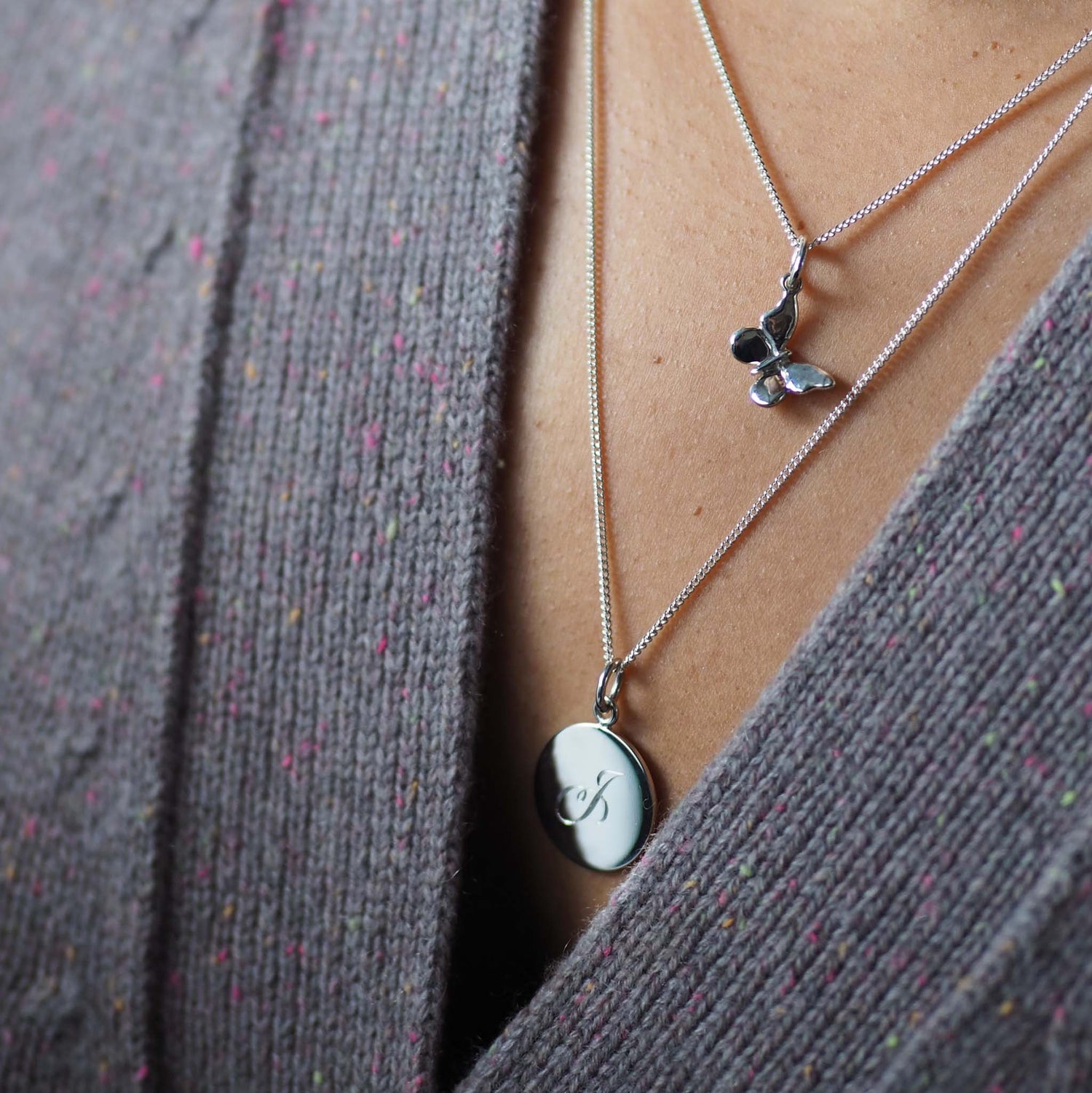 Woman wearing the Butterfly Necklace in solid gold layered with initial pendant, a modern talisman of change and new beginnings