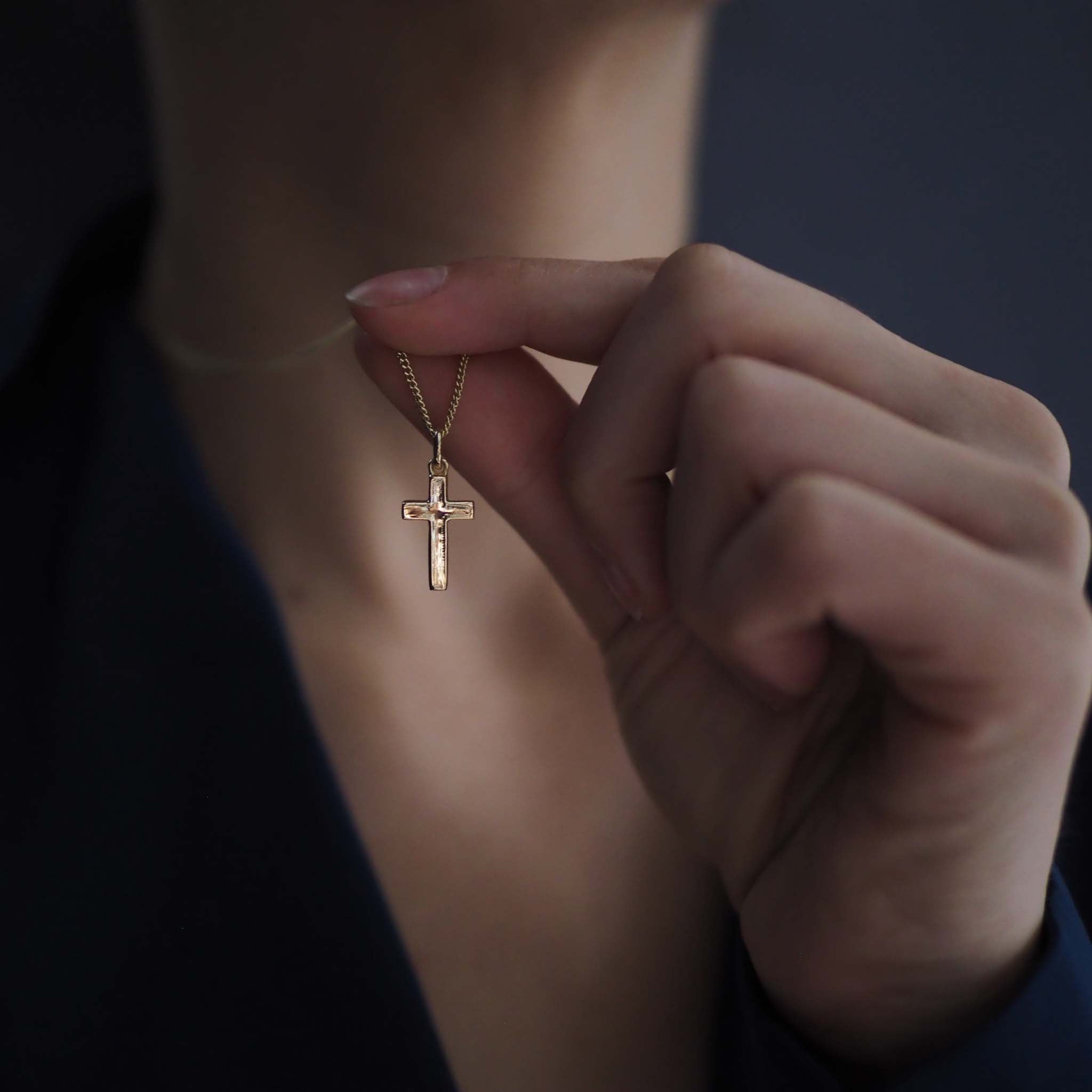 Model and close-up of the Solid Gold Cross Necklace with handcrafted texture and sculptural design
