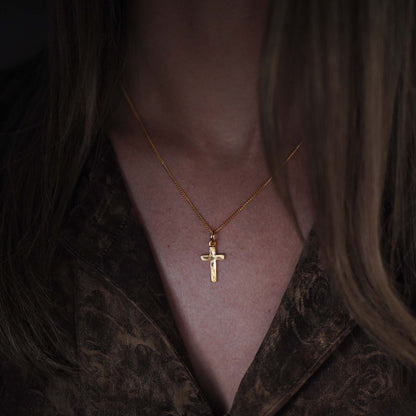 Woman wearing the Solid Gold Cross Necklace and a brown silk shirt, a modern heirloom symbol of faith and love