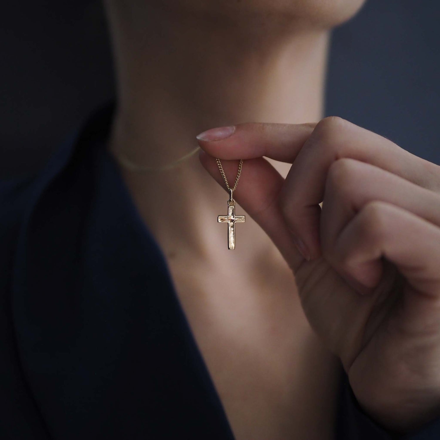 Woman wearing the Solid Gold Cross Necklace, a modern heirloom symbol of faith and love