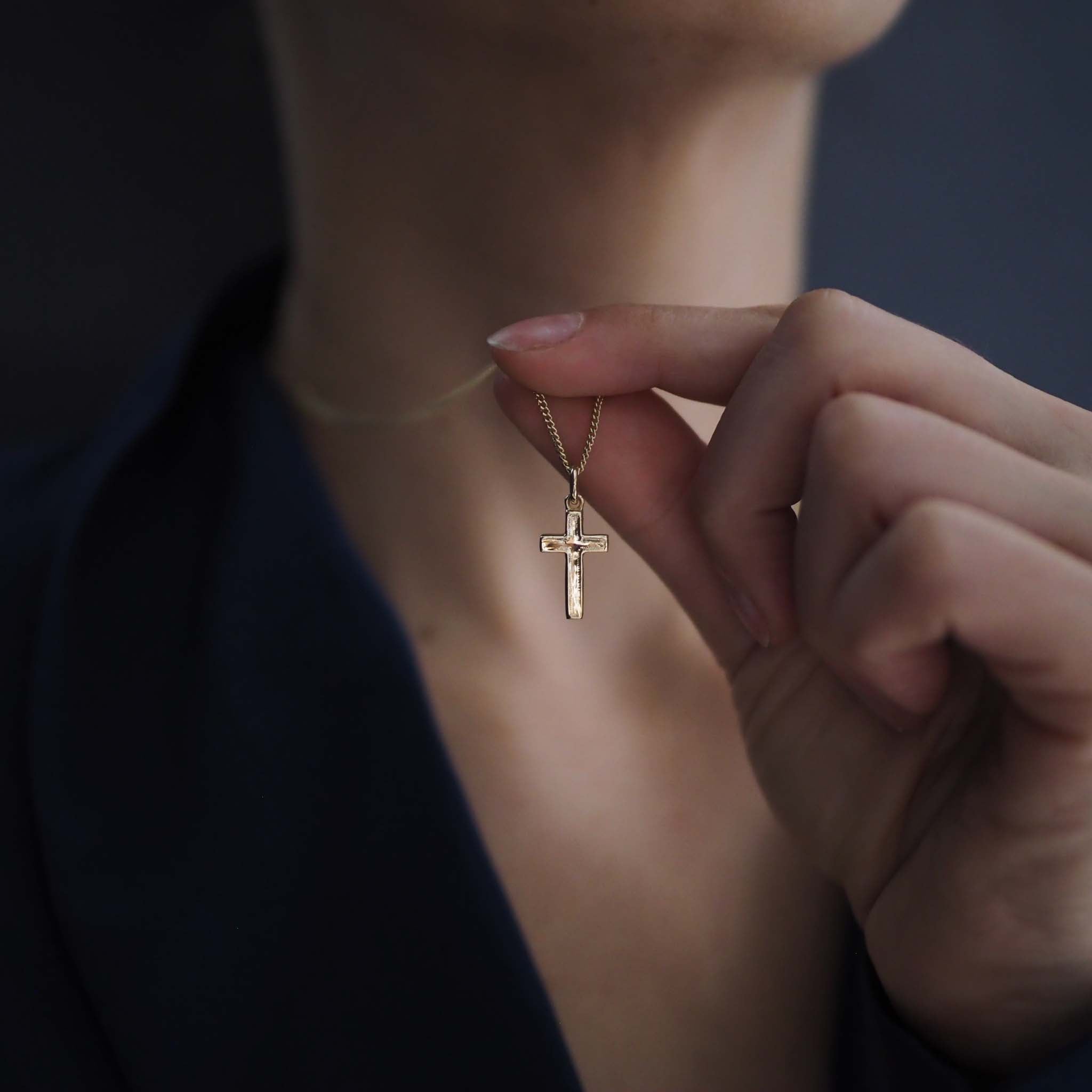 Woman wearing the Solid Gold Cross Necklace, a modern heirloom symbol of faith and love