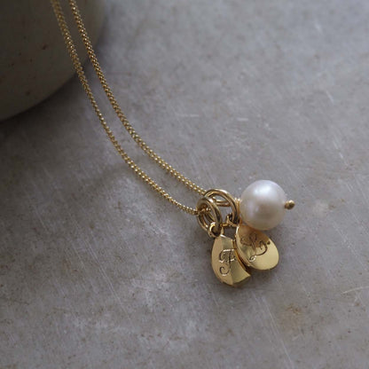 Initial Double Teardrop and Pearl Necklace in solid gold with engraved charms and freshwater pearl on side angle