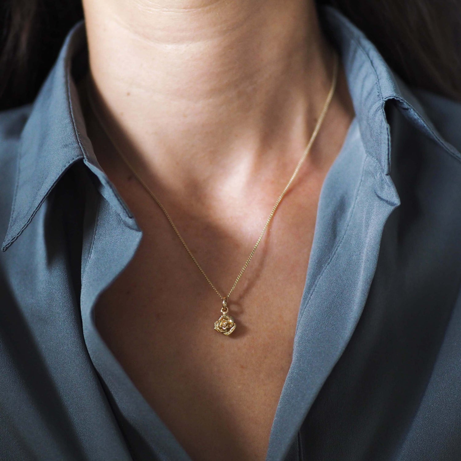 Woman wearing the Rose Necklace in 9ct solid gold, a talisman of love, resilience, and quiet strength