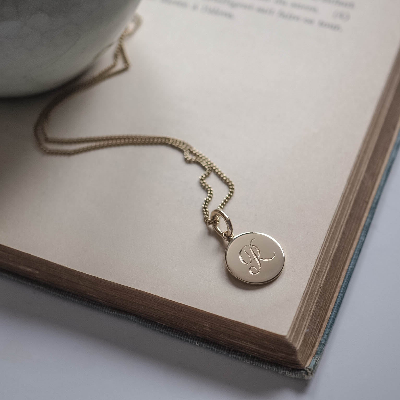 Initial Mini Necklace in Solid Gold with a hand-engraved scrolled initial, available in yellow, rose, or white gold. A delicate piece for personal storytelling and meaningful gifting.