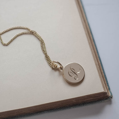 Initial Mini Necklace Bianca Jones Initial Mini Necklace in Solid Gold with a hand-engraved scrolled initial, available in yellow, rose, or white gold. A delicate piece for personal storytelling and meaningful gifting.