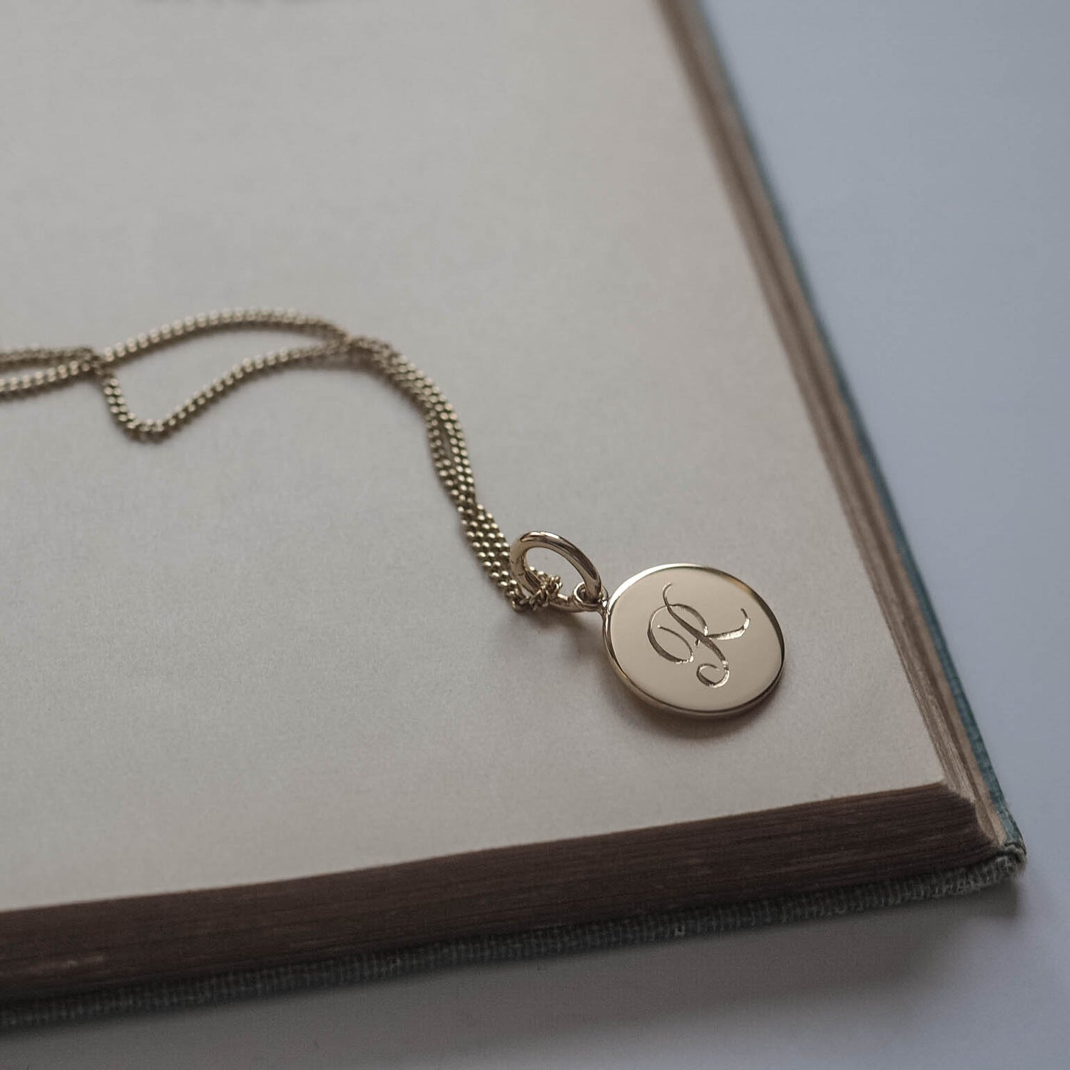 Initial Mini Necklace in Solid Gold with a hand-engraved scrolled initial, available in yellow, rose, or white gold. A delicate piece for personal storytelling and meaningful gifting.